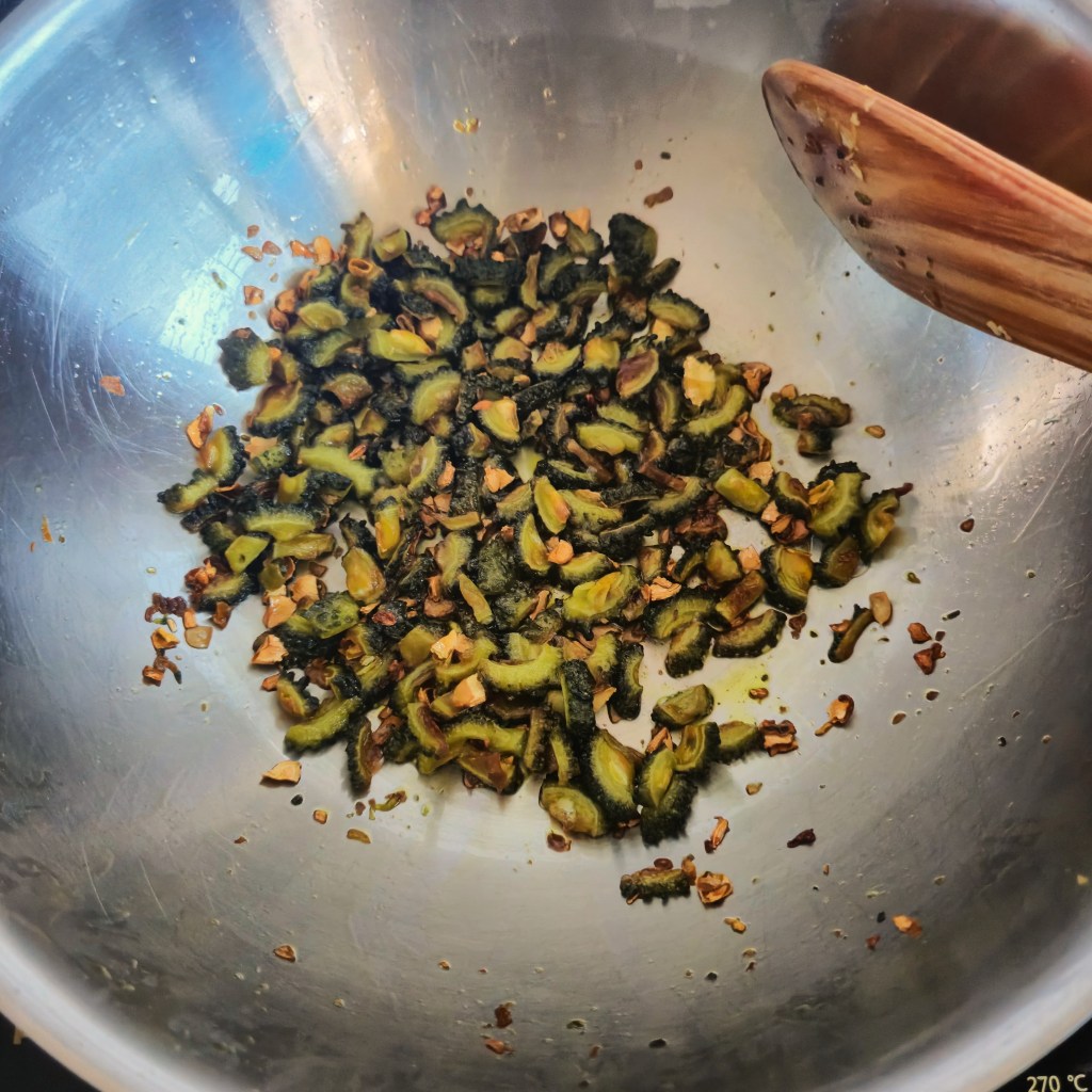 Frying the chopped bitter gourd