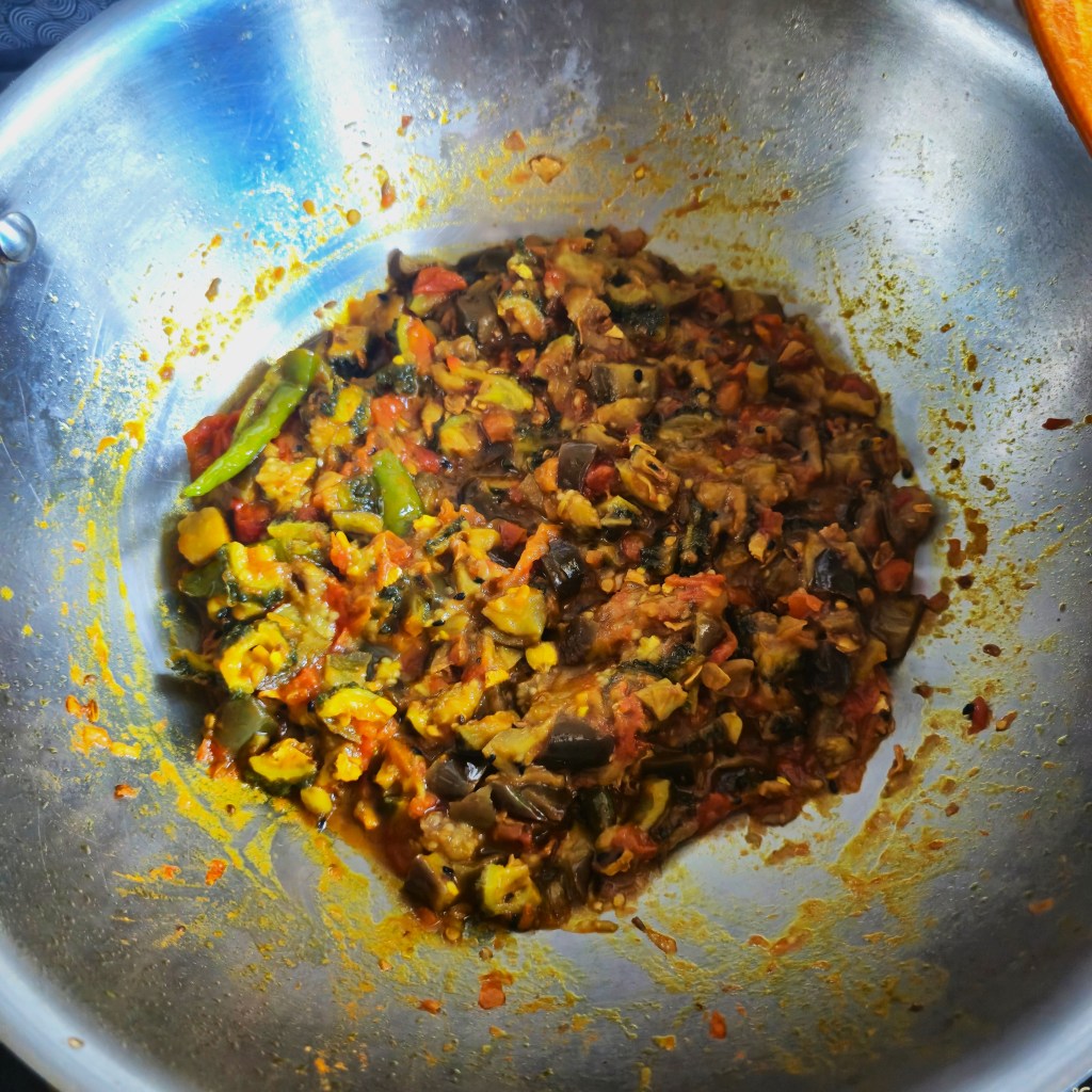 Cooking after adding the fried brinjal and bitter gourd