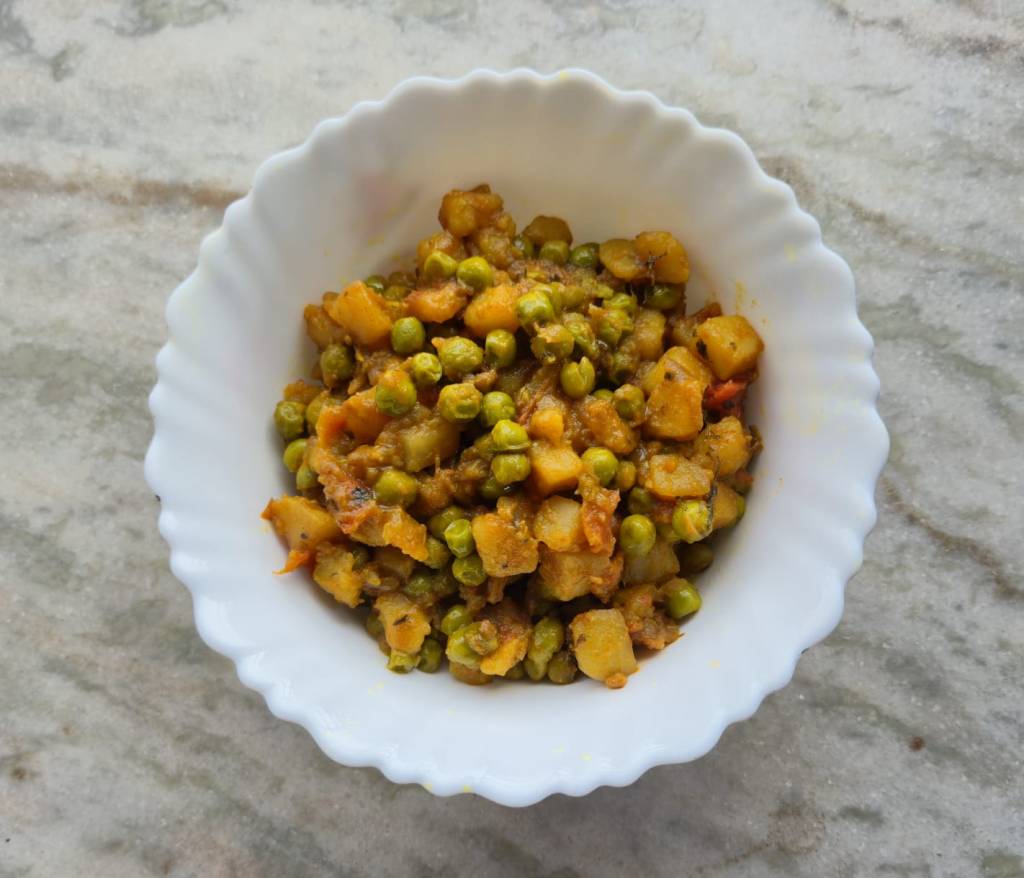 A bowl full of potato and green peas curry